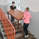 Lehrer tragen Tisch die Treppe runter
