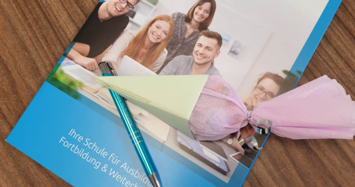 Eine Zuckertüte liegt auf einer Einschulungsmappe