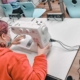 Auszubildende Kinderpfleger lernen den Umgang mit der Nähmaschine