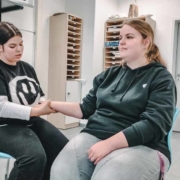 Auszubildende Pflegefachfrauen führen eine Handmassage durch