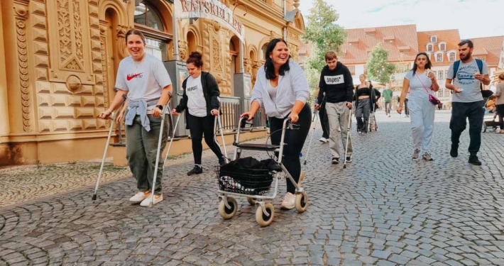 Auszubildende Pflegefachkräfte üben mit Mobilitätshilfen